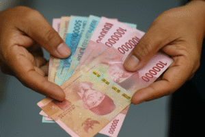 Penerima Bansos Bogor tangan memegang lembaran uang rupiah sebagai ilustrasi bantuan sosial pemerintah