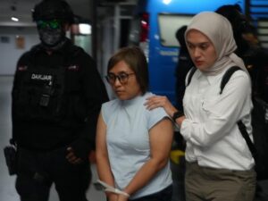 Dewi Astutik narkoba, perempuan berkacamata duduk di dalam mobil usai diamankan polisi dalam kasus peredaran narkotika